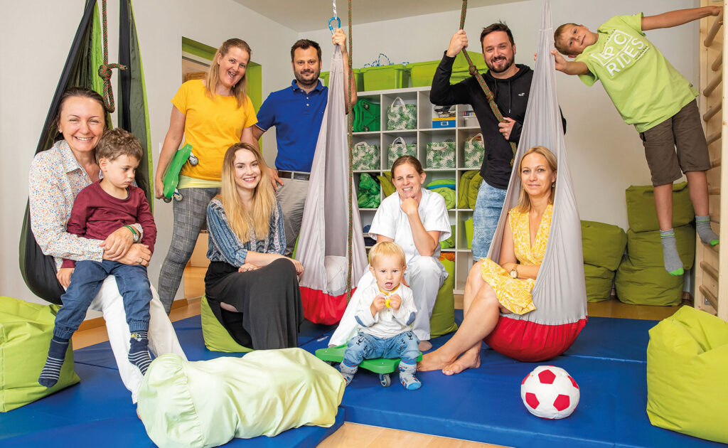 Beruf und Familie lassen sich im DOKH perfekt unter einen Hut bringen. Tagesmütter Sladana Kerschbaumer und Silvia Ettinger, Assistenzärztin Dr. Simona Svrbicka, DOKH Projektleiter Andreas Dabernig, Diplomkrankenschwester Michaela Pemberger mit Niklas, Physiotherapeut David Obmann, DOKH Projektleiterin Jasmine Gesson und Michael