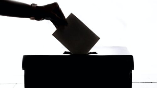 Ein verschlossenes Kuvert wird in die Wahlurne eingeworfen