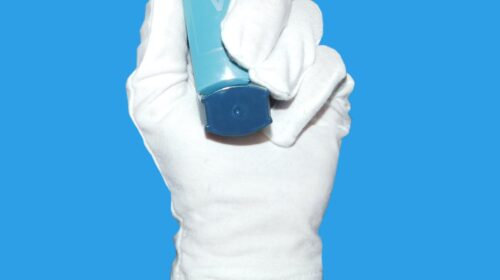 Ein Ihnhalator in einer Hand mit Handschuh