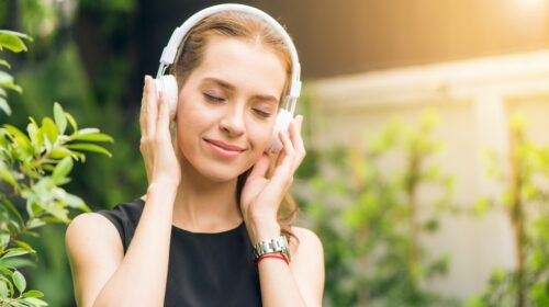 Eine Frau mit einem weißen Over-Ear-Kopfhörer