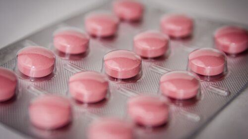 Ein Medikamentenblister mit rosa durchschimmernden Pillen