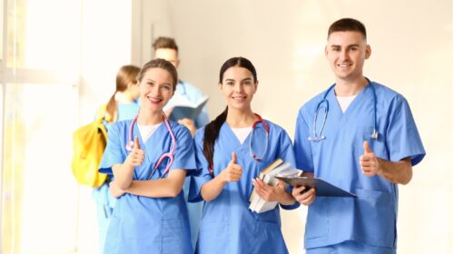 Gruppe von Medizinstudierenden, die in der Klinikhalle eine Daumen-nach-oben-Geste zeigen